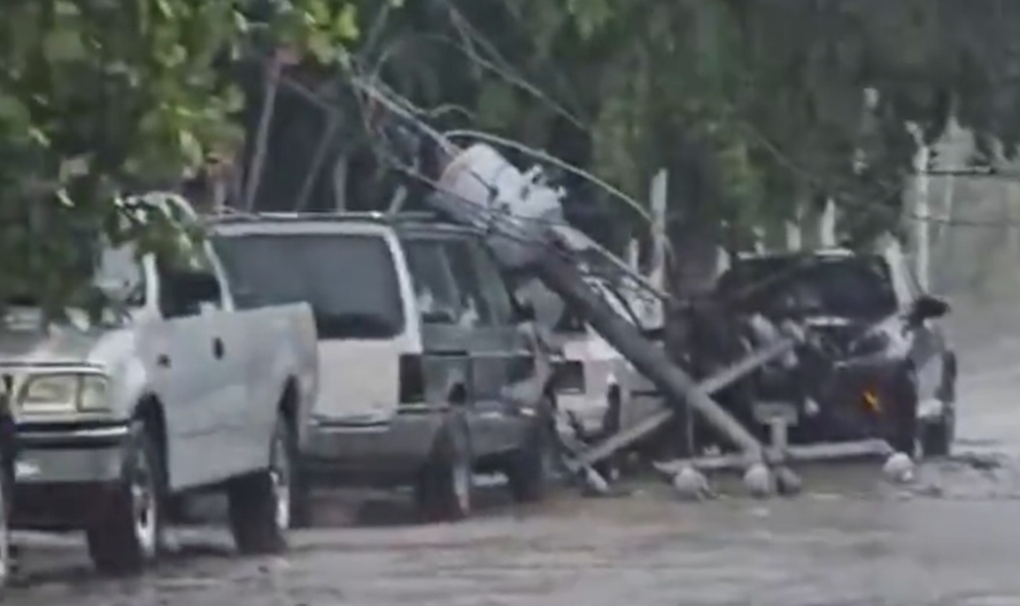 Lluvias derriban poste de CFE sobre vehículos en Cancún